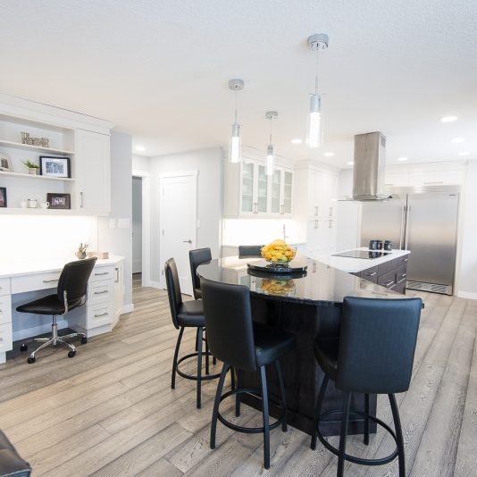 kitchen renovation project with white cabinets and half moon marble breakfast bar with bar stools