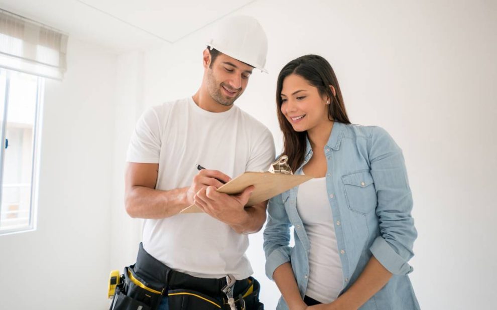 A contractor holding a writing pad in front of the landlord.