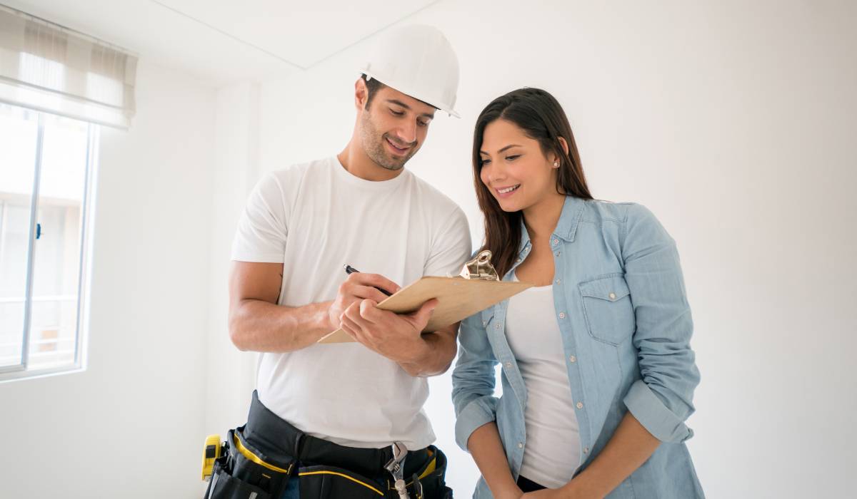 A contractor holding a writing pad in front of the landlord.