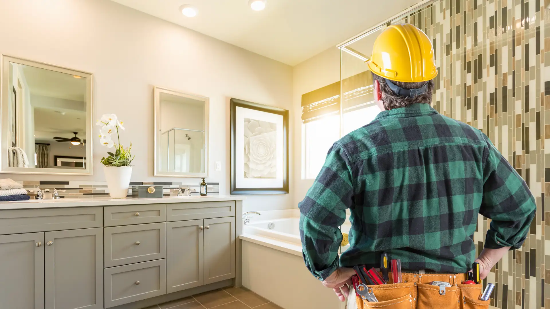 home-addition-1 A home renovation contractor in a hard hat standing in front of a bathroom