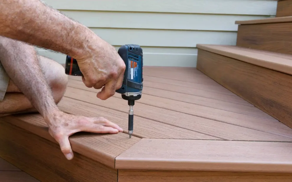 a person using a power drill to install a wooden deck