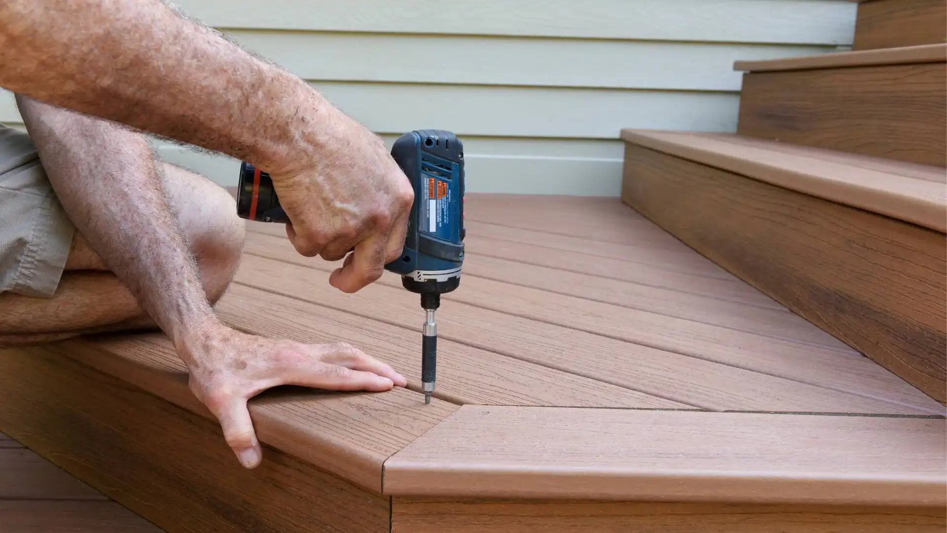 home-renovations-1 a person using a power drill to install a wooden deck