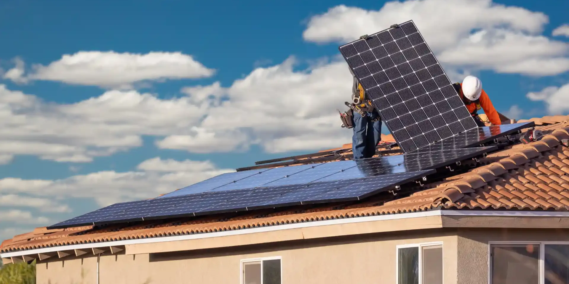 Contractors installing solar panels on the roof