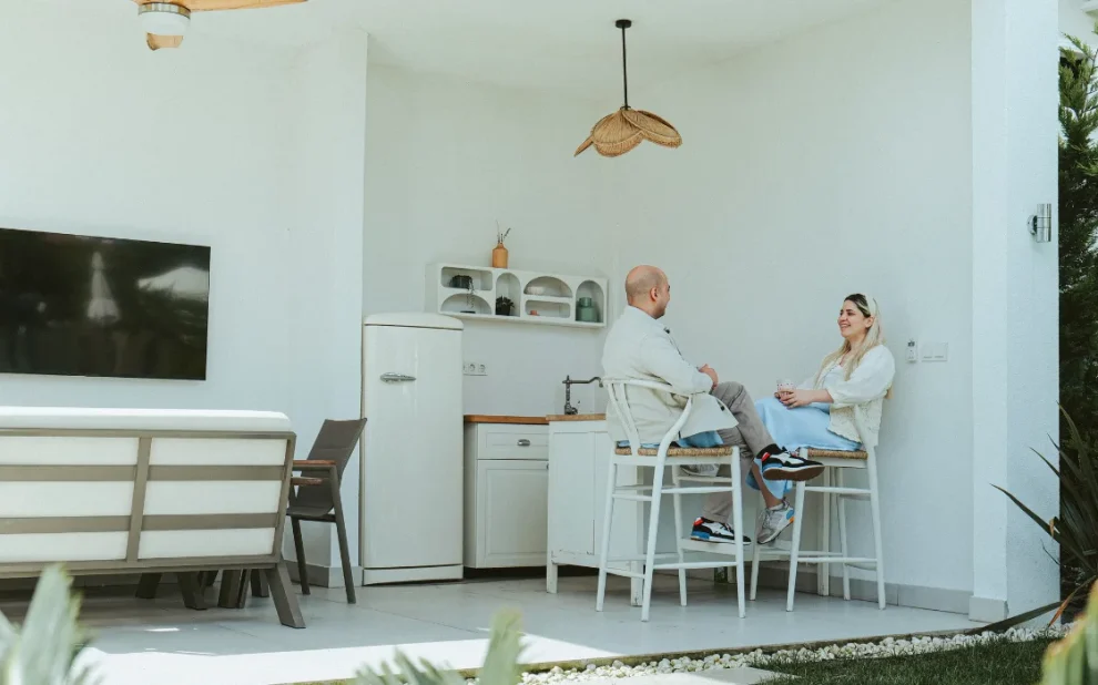 Couple taliking and sitting on their outdoor kitchen