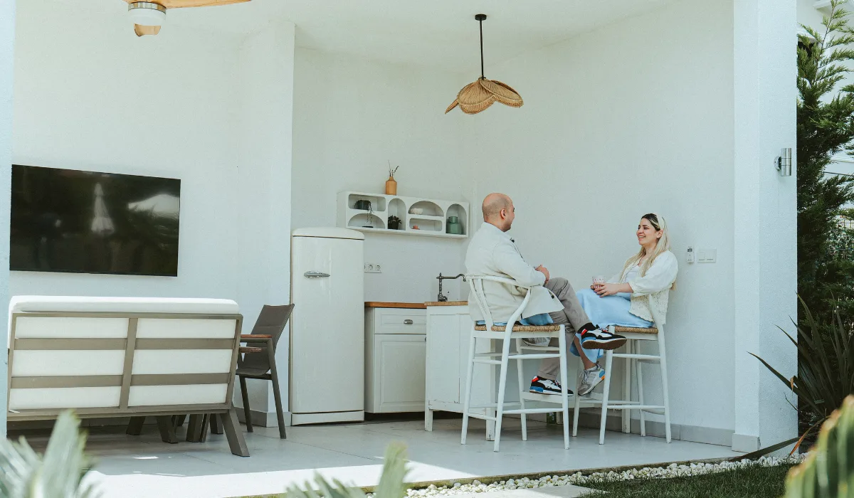 Couple taliking and sitting on their outdoor kitchen