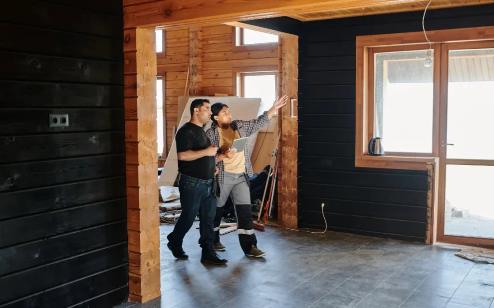 A couple standing in an unfinished house.