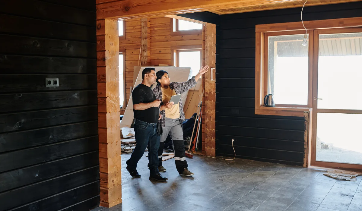 A couple standing in an unfinished house.