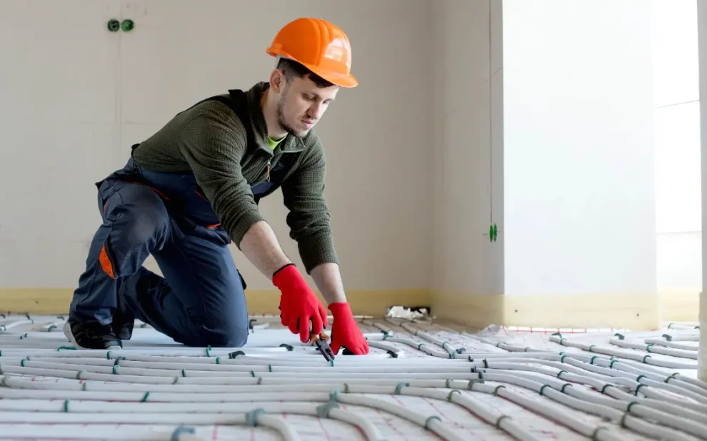 A contractor is installing heated floors inside a living room