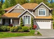 Luxury custom home exterior with landscaped front yard and driveway