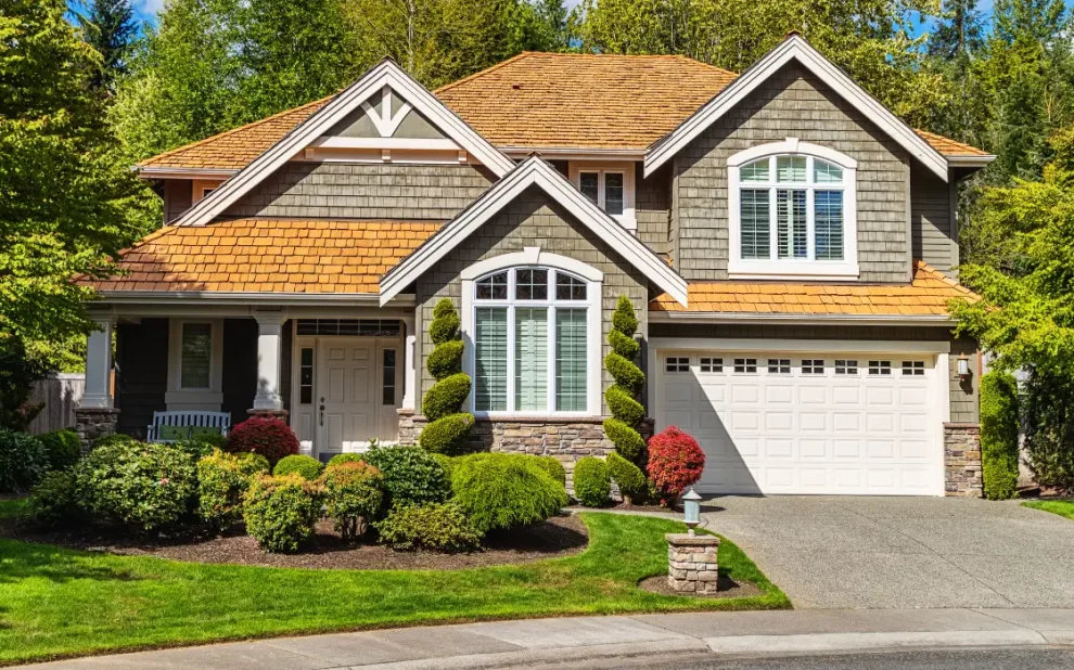 Luxury custom home exterior with landscaped front yard and driveway